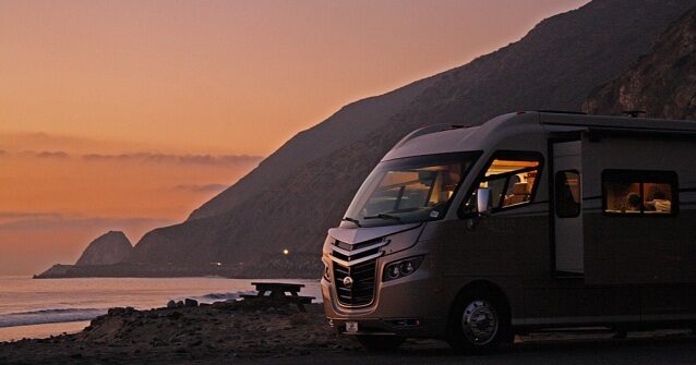 sunset next to the coast with and RV