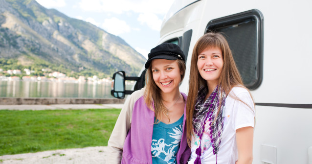 two women next to a RV